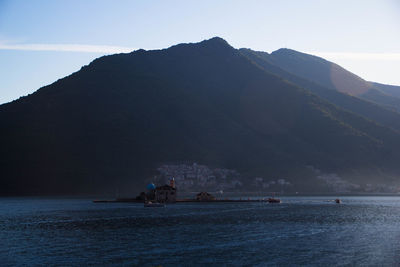 Scenic view of sea and mountains against sky