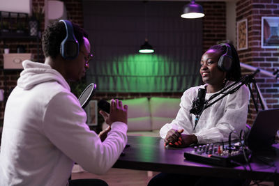 Young man and woman podcasting at studio