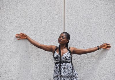 Full length of woman standing against wall