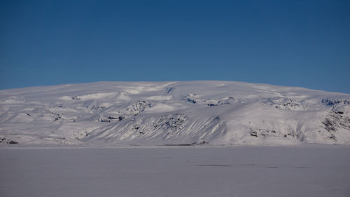 Scenic view of snowcapped mountains against clear blue sky