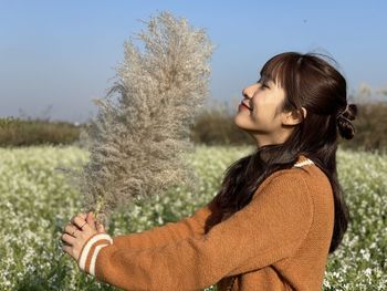 Portrait of woman standing on field against sky