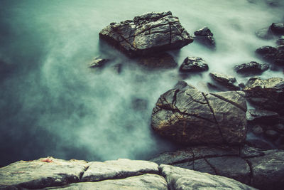 Rocks in sea against sky