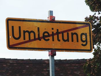 Low angle view of road sign against clear sky