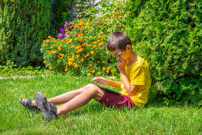 Side view of girl sitting on grass