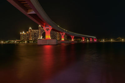 Illuminated bridge over river at night