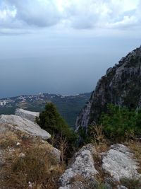 Scenic view of landscape by sea against sky