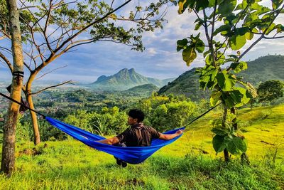 Rear view of man sitting on grass