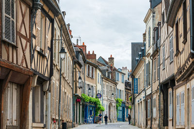 Alley amidst buildings in city against sky