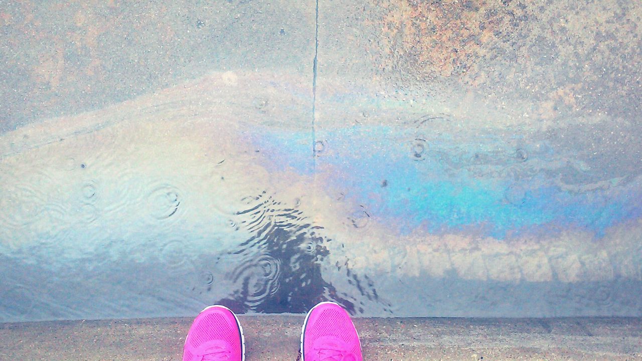 water, low section, person, wet, personal perspective, lifestyles, standing, part of, human foot, reflection, leisure activity, pink color, outdoors, unrecognizable person, day, shoe, nature