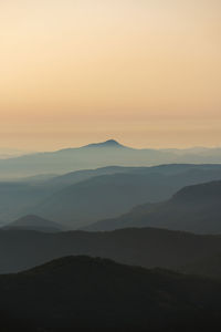 Scenic view of silhouette mountains against sky during sunset