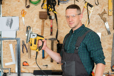 Portrait of young man standing in factory