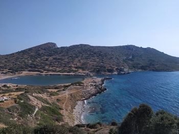 Scenic view of sea and mountains against clear sky