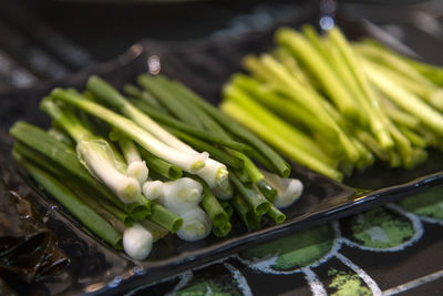 High angle view of chopped vegetables of green onion and water  parsley on plate 