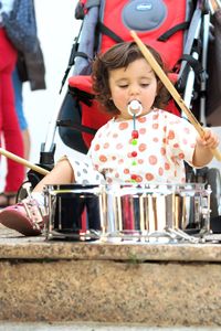 Cute girl banging drum on stage