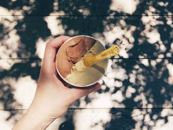 Cropped hand holding ice cream outdoors