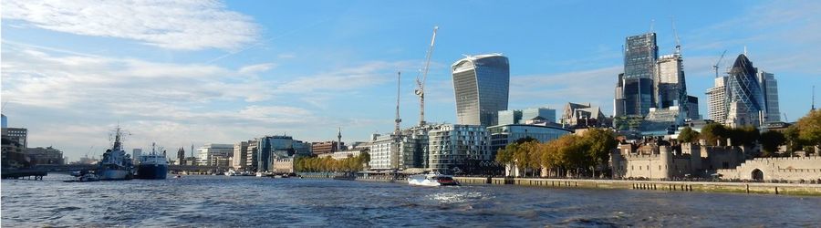 Sea by buildings against sky in city