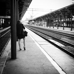 Woman walking on railroad track