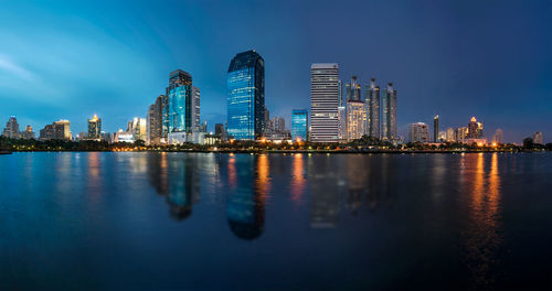 River by illuminated buildings against clear sky