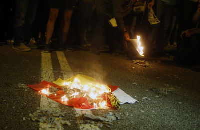 Low section of people on fire in city at night