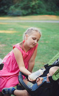 Full length of girl sitting on field