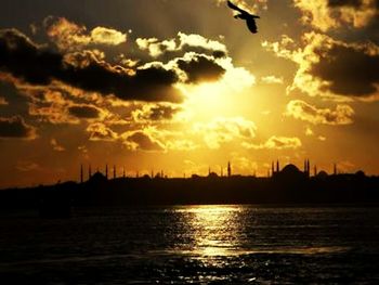 Scenic view of sea against cloudy sky at sunset