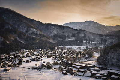 High angle view of snowcapped mountain against sunset in shirakawa-go village japan hut 