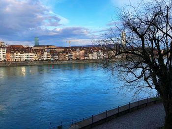 Scenic view of river by buildings against sky