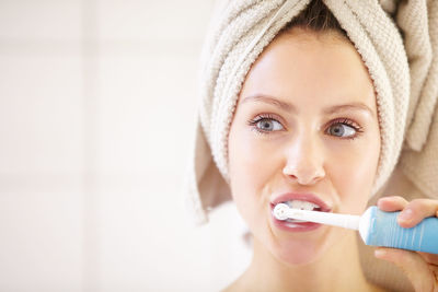 Woman brushing teeth at home