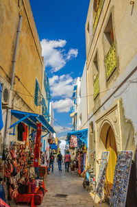 People walking on street amidst buildings in city