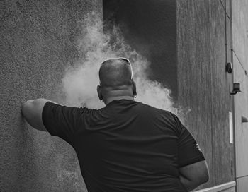 Rear view of man standing against wall