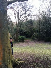 Woman standing on tree trunk