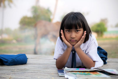 Portrait of girl sitting on table