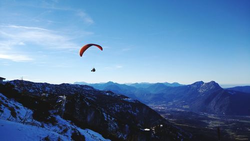 Person paragliding against sky