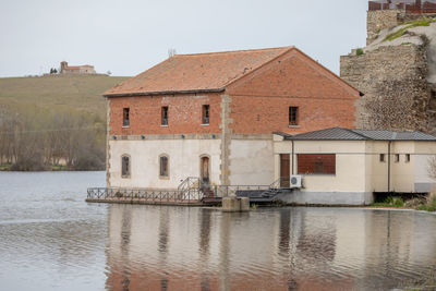 Building by river against sky