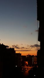 Illuminated city against sky during sunset