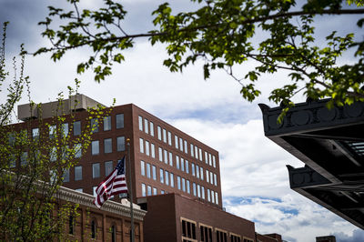 Low angle view of america flag and buildings against sky