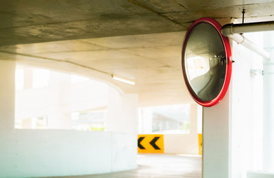 Convex safety mirror at curve of indoor car parking lot to reduce risk of accidents from blind 