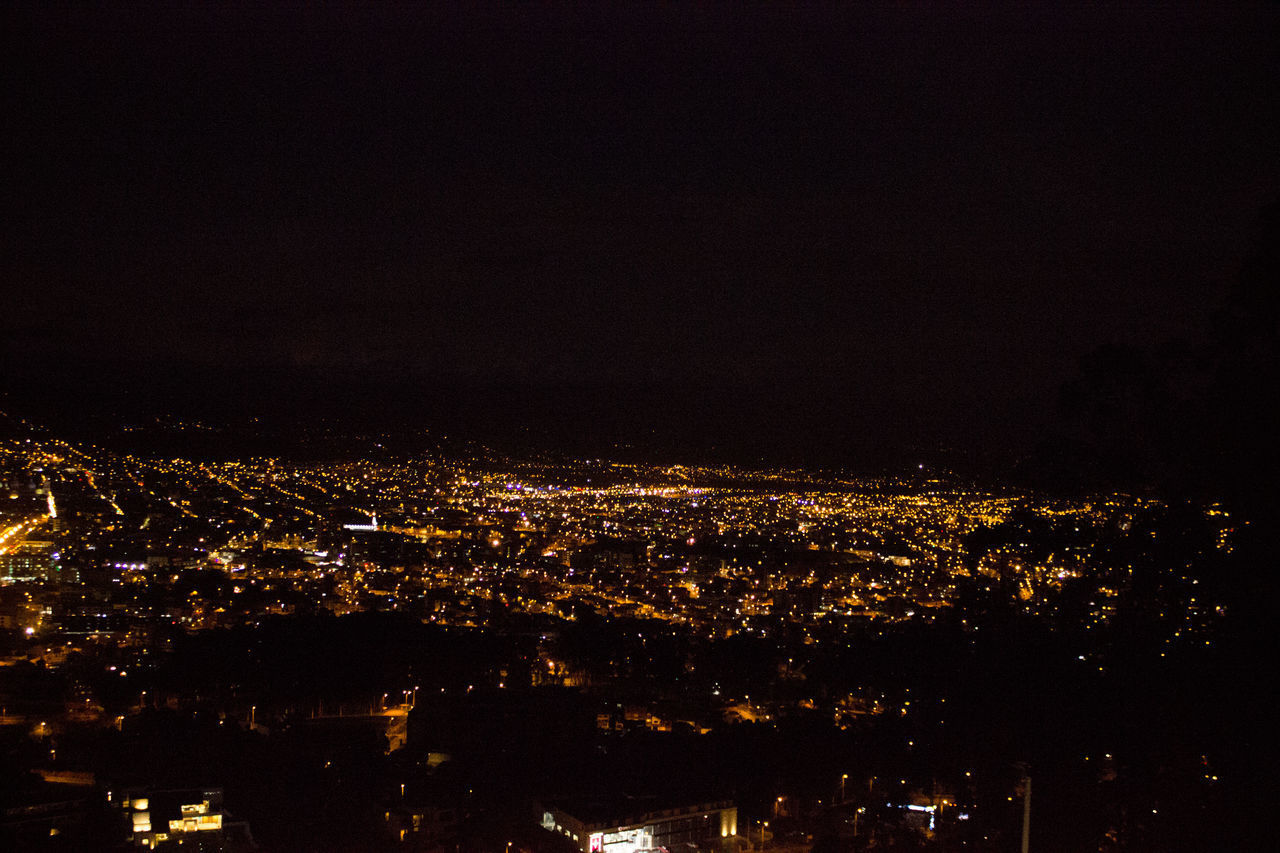 HIGH ANGLE VIEW OF ILLUMINATED BUILDINGS IN CITY AGAINST SKY