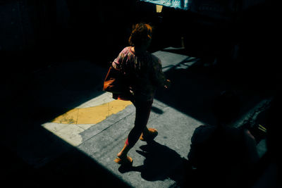 Rear view of woman walking on street in city