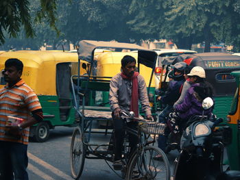 People riding old bicycle on road