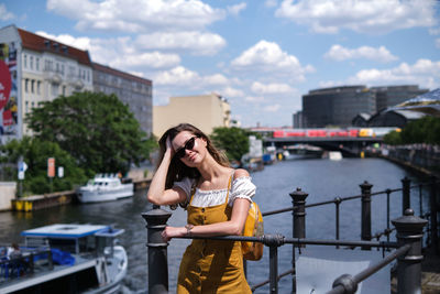 Full length of woman standing on mobile phone in city