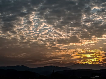 Scenic view of silhouette mountains against romantic sky