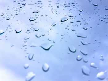 Full frame shot of raindrops on blue glass