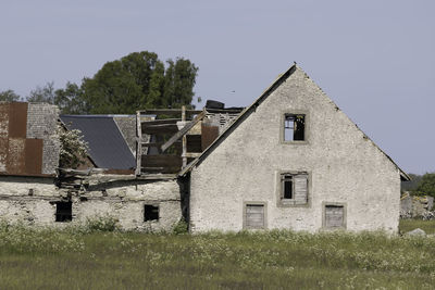 Old building by trees against clear sky