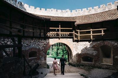 Rear view of people walking on historic building