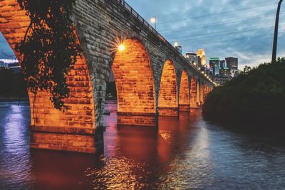 Arch bridge over river against buildings