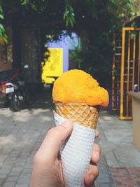 Midsection of person holding ice cream cone. mexican colors.