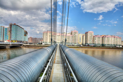 Bridge by buildings against sky in city