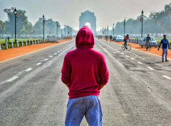 Rear view of a man standing on road
