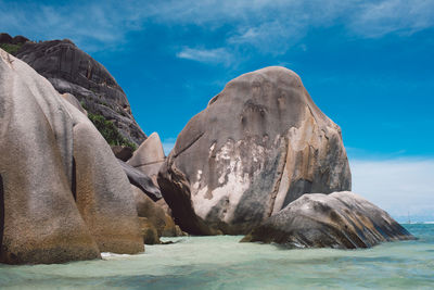 Rock formations by sea against sky